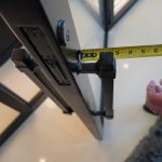 This modern wine room has a single glass door that opens and closes using a brushed metal black door handle.