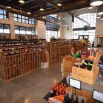 From this picture, you can clearly see the high-ceiling design of this custom commercial wine cellar and the big French windows. The team kept the space feel big and open by installing low-standing wine racks.
