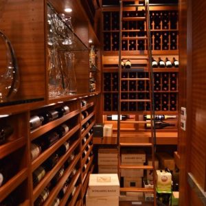 12 - This gorgeous luxury traditional home wine cellar features multiple racking styles, a rolling ladder, and custom LED lighting. Large Capacity Custom Wine Cellar