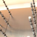 Brushed chrome metal rods are attached onto stainless steel backer boards.