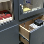 Sub-closing cabinets are part of this small wine cellar's cigar storage. The machine you see inside the drawer is the self-replenishing humidification system.